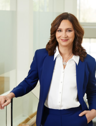 BBW CEO Gina Boswell, smiling at the camera with one hand in her pocket