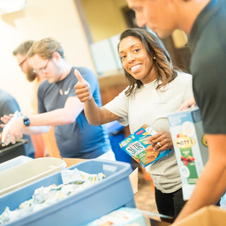 A Bath & Body Works employee looking at the camera and giving a thumbs up.
