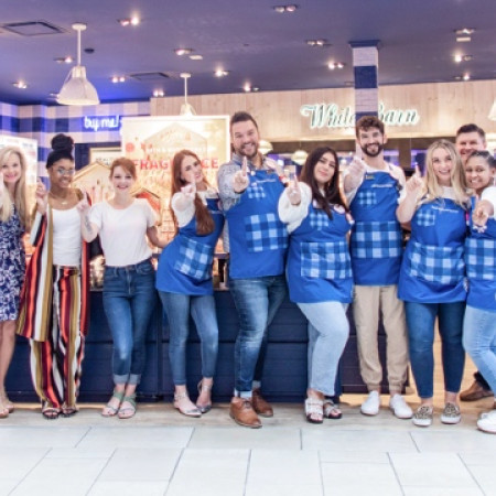 Two people walking and talking in an office setting.