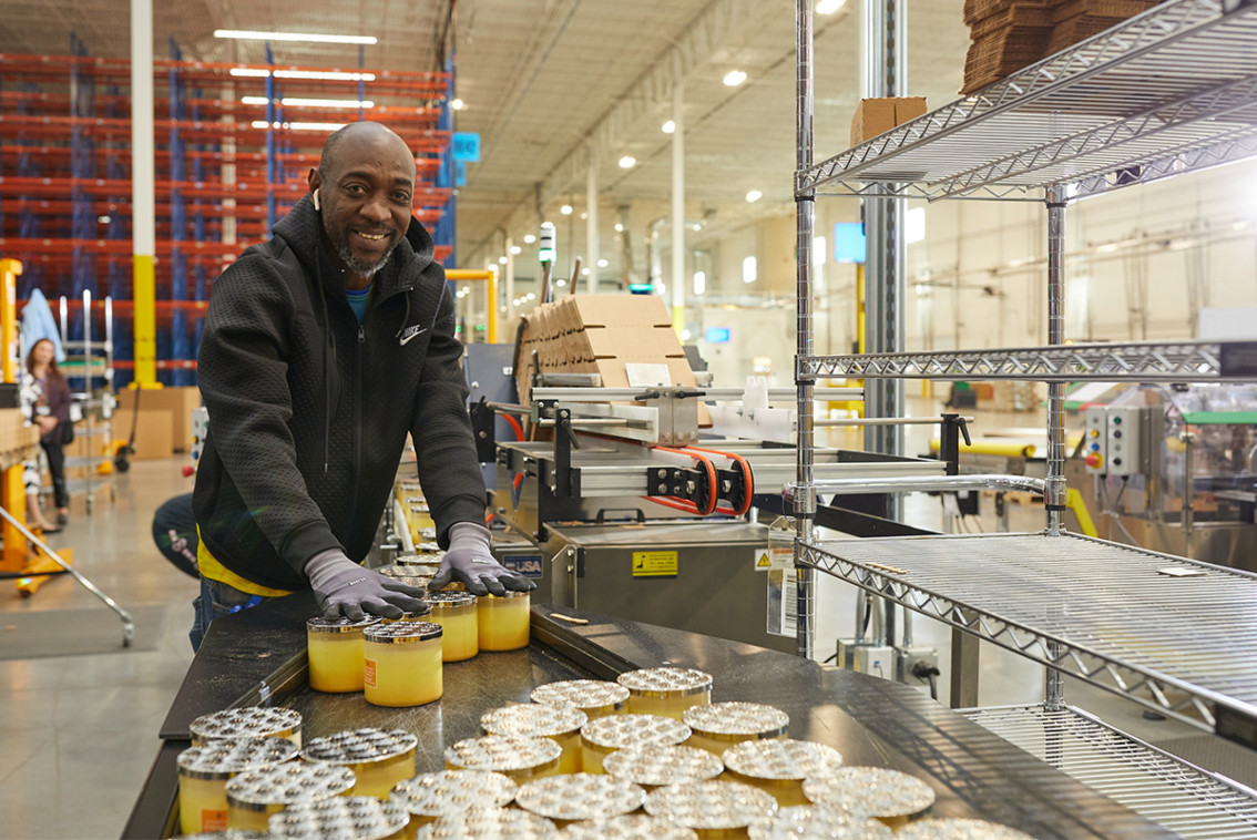 BBW associate handling candles in a distribution center.